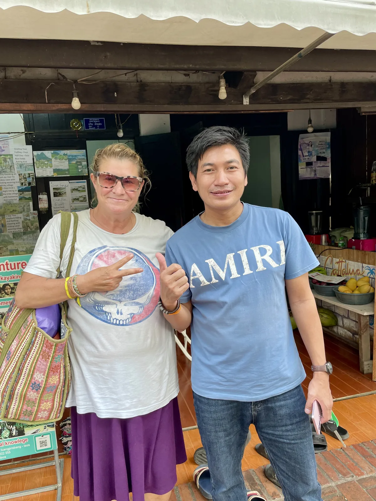 A woman in a Grateful Dead t-shirt and a Laotian man on the street in Laos