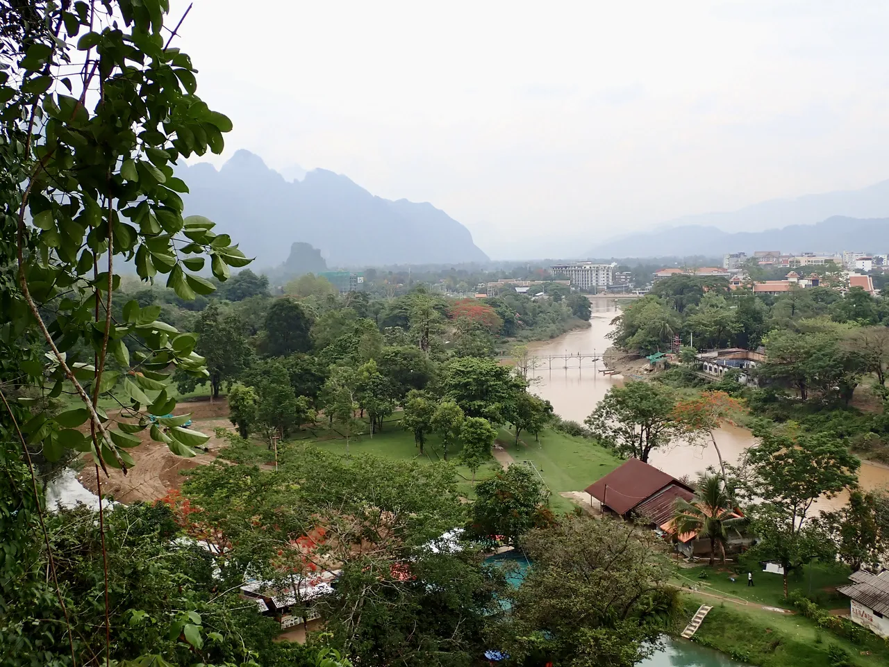 View over Vang Vieng town, the Nam Song river and a bridge with the karst mountains in the distance