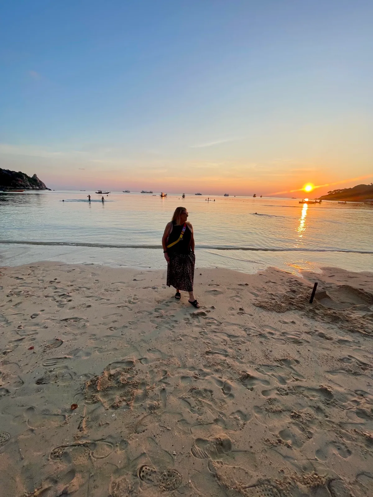 A woman alone on a beach at sunset in Chalok Bay Koh Tao Thailand