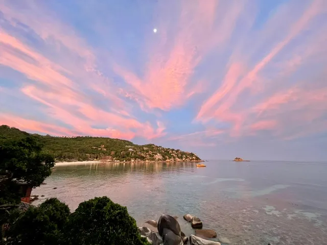 The sunset with a full moon shining over a bay on Koh Tao Thailand